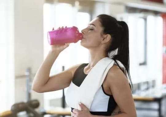 A woman drinking pr-workout supplements.