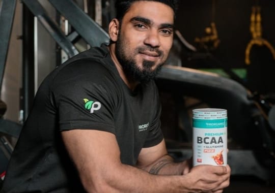 A man holding a bottle of beta-alanine and BCAA.