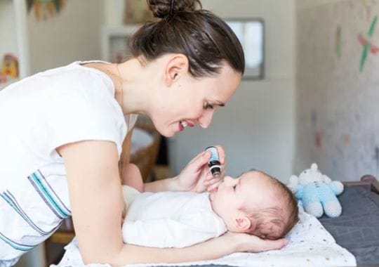 A mother giving her baby Vitamin D.