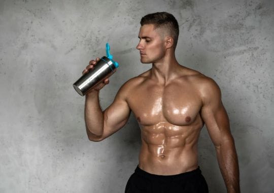 A man holding a bottle of pre workout.