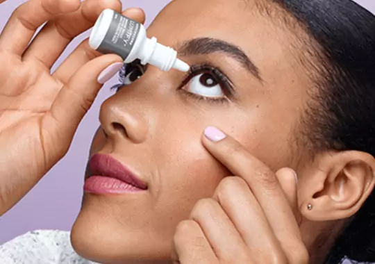 A woman applying eyedrops in the eyes.