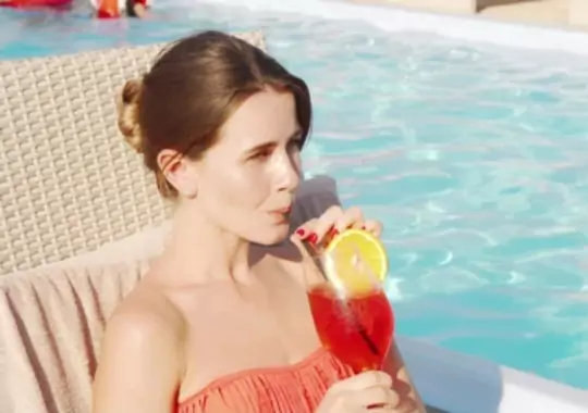 A woman drinking a cocktail.