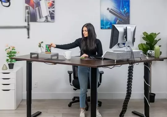 A woman standing with a fezibo standing desk.