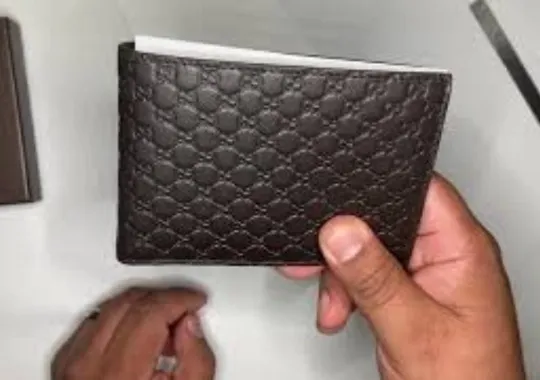 Person holding a Gucci wallets.