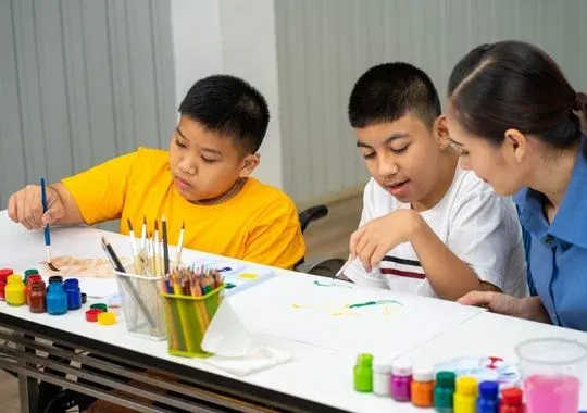 Autistic Children with teacher learning color paint in classroom.