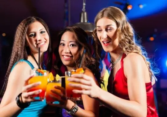 Young ladies drinking cocktail drinks.