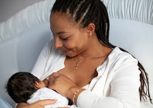 A Woman Breastfeeding A Newborn Baby.