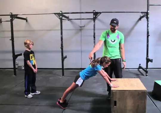 A man training kids with fitness workouts.