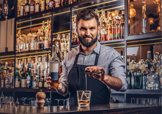 A man making a drink in a bar.