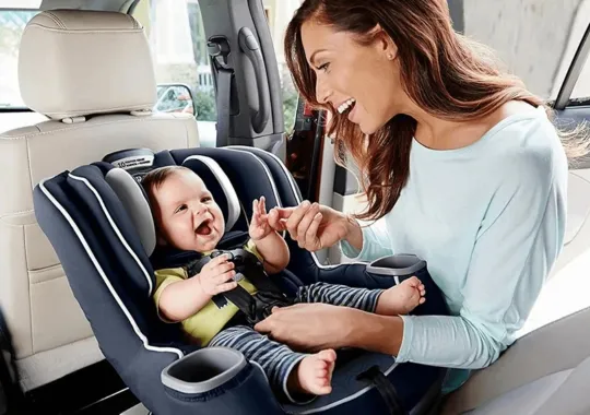 A baby seating on a baby car seat.