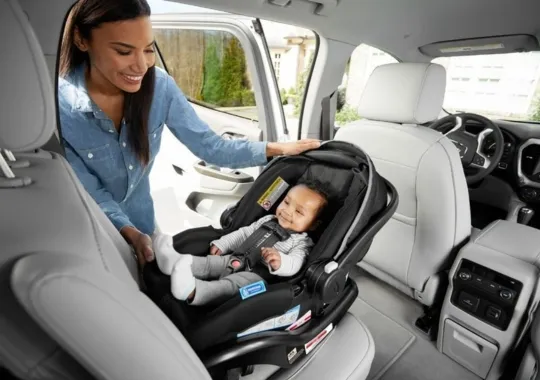 A woman rotating a baby's car seat.