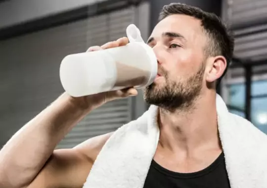 A man drinking a supplement.