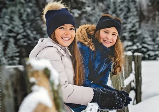 Two girls wearing winter clothes.