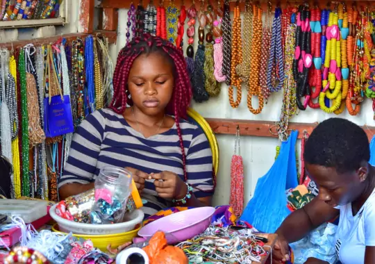 A woman making different types of bracelets.